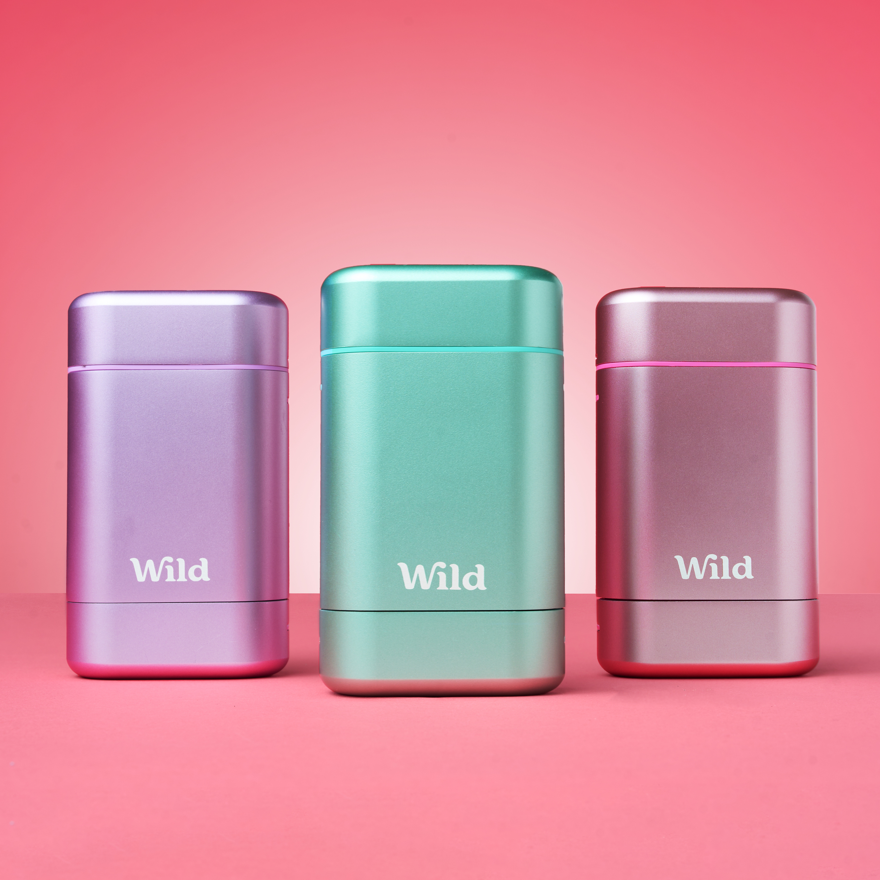 Caption: three different colored metal containers on a pink background