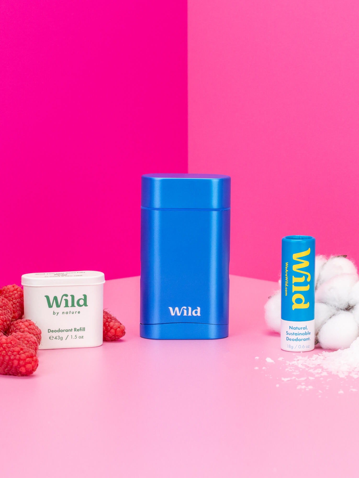 Bijschrift: frambozen, yoghurt en een blauw bakje op een roze tafel