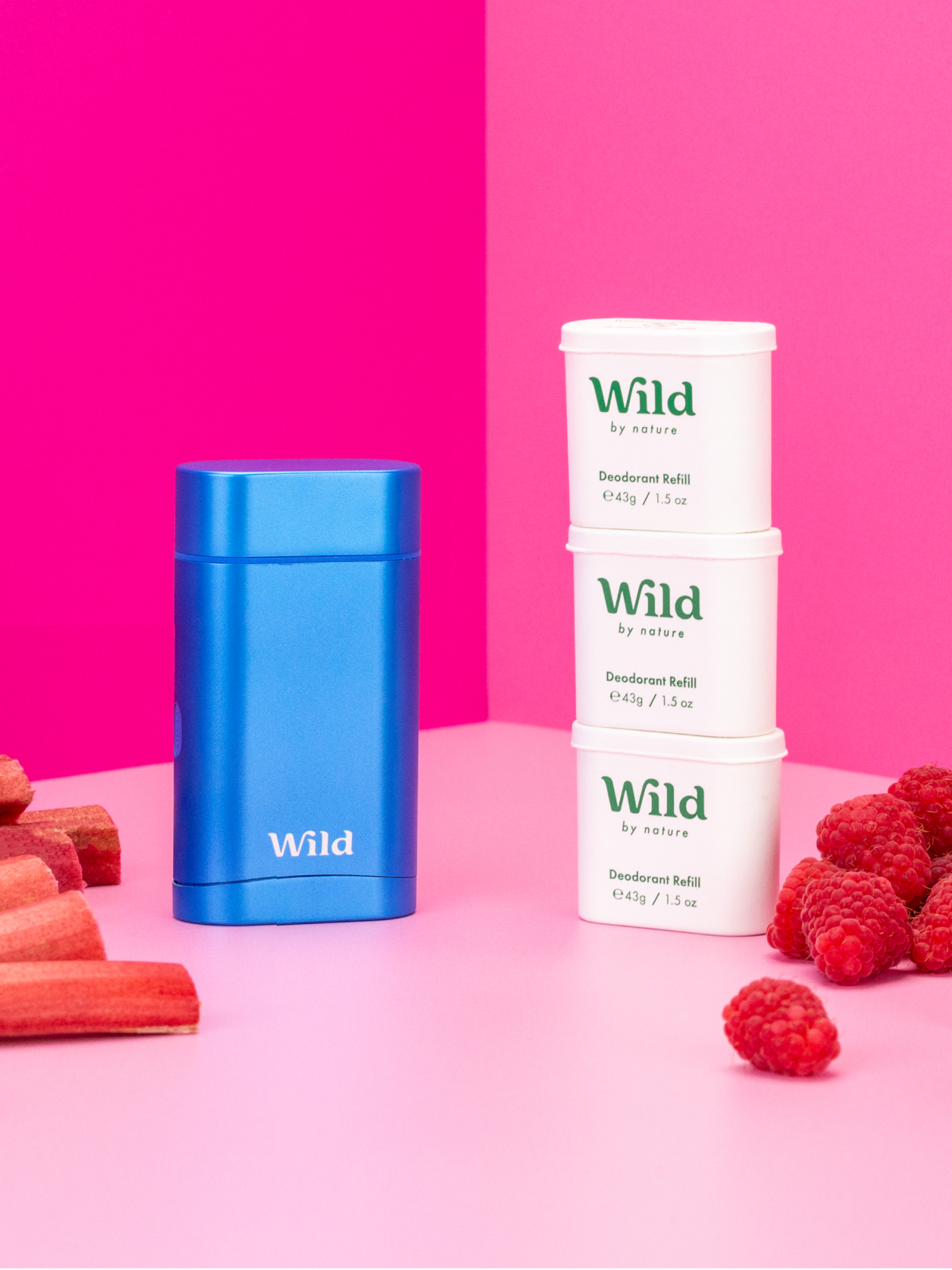 Caption: three containers of wild raspberries and carrots on a pink background