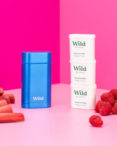 Caption: three containers of wild raspberries and carrots on a pink background