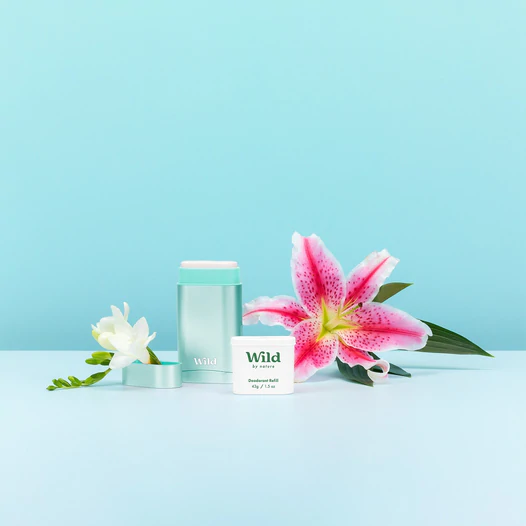 Bijschrift: een roze bloem naast een witte container