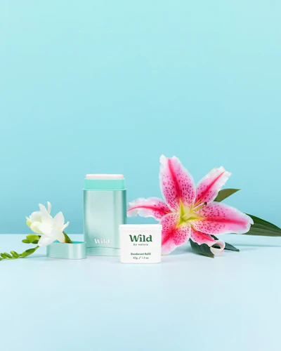 Pie de foto: una flor rosa junto a un recipiente blanco