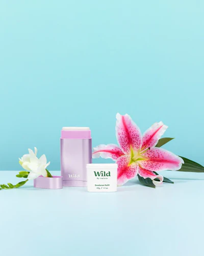 Caption: a pink and white flower next to a pink and white tube