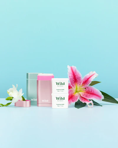 Pie de foto: una flor rosa y blanca junto a una caja rosa y blanca