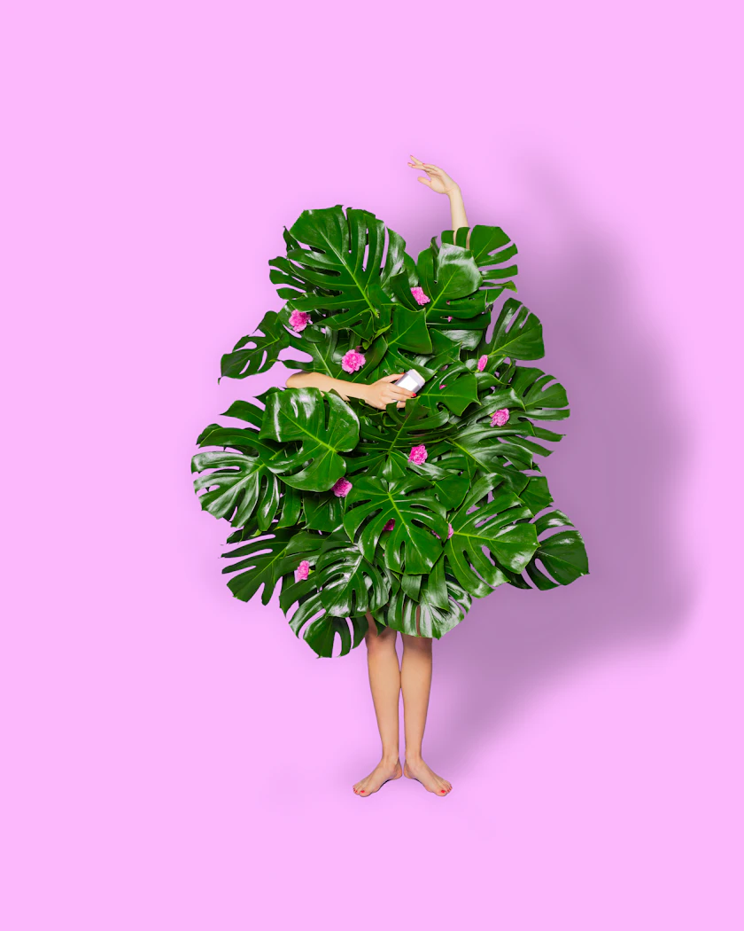 Caption: a woman standing in front of a large green plant