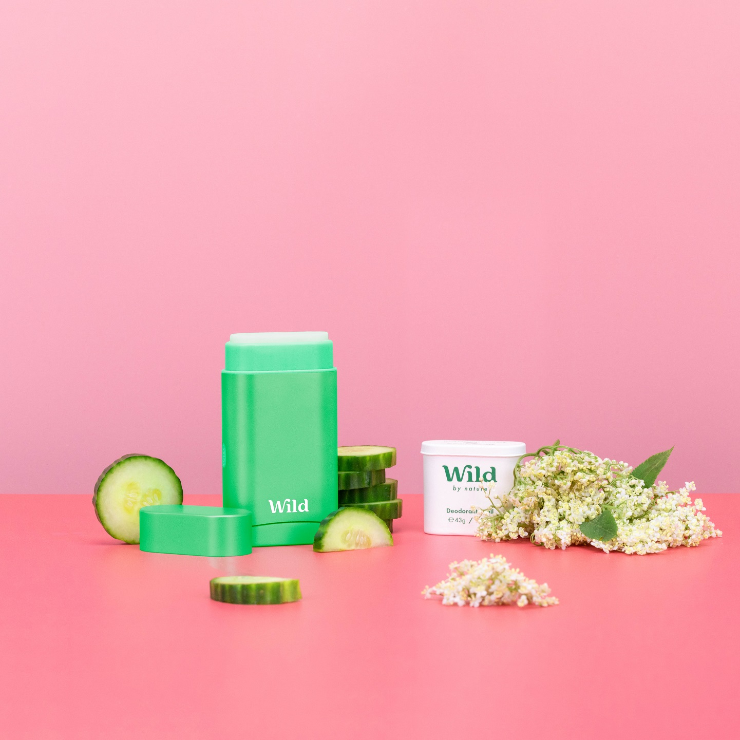 Bildunterschrift: ein rosafarbener Tisch mit einem Behälter mit Sahne und einer Gurke