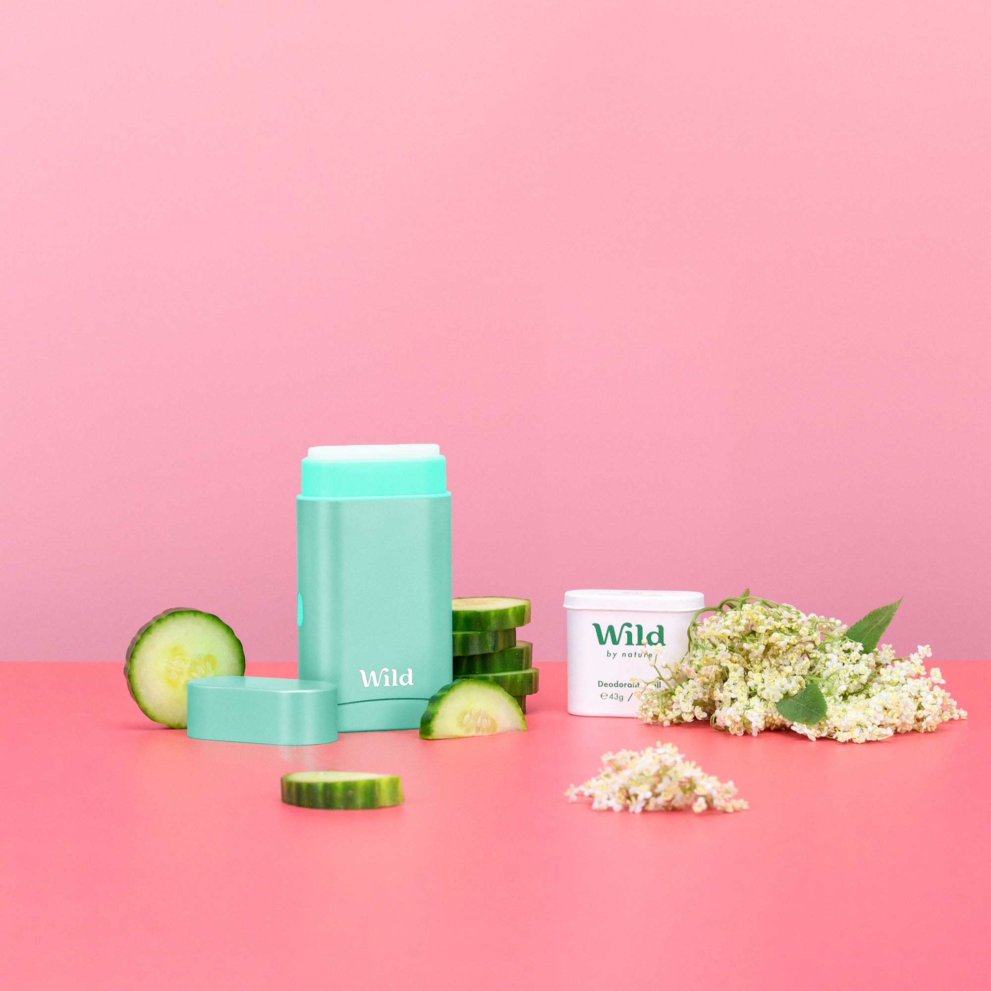 Caption: a pink table topped with a container of cream and cucumber