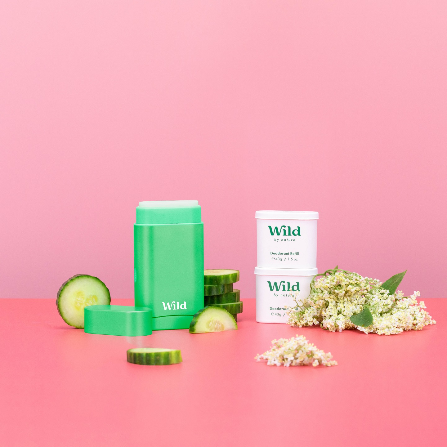 Caption: a pink table topped with green containers and a cucumber