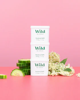 Bildunterschrift: ein Stapel von drei weißen Behältern, die auf einem rosa Tisch stehen