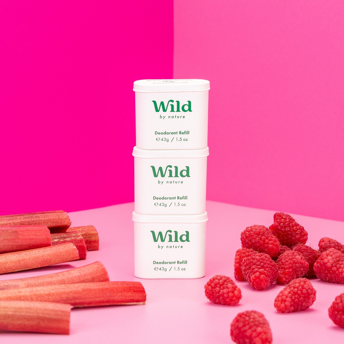 Bijschrift: een stapel van drie witte bakjes gevuld met frambozen naast een stapel