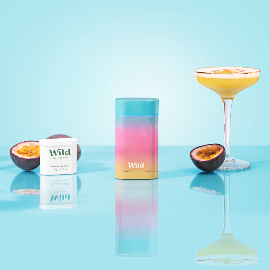 Caption: a glass of orange juice next to a bottle of wild