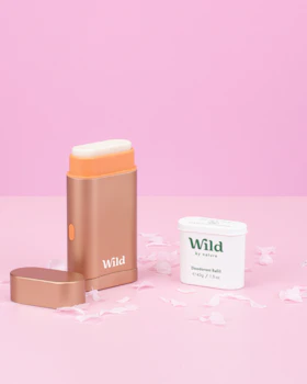 Caption: a pink background with a gold lipstick and a white container