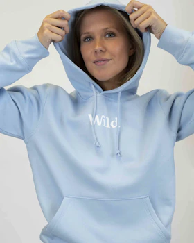 Caption: a woman in a blue hoodie is holding her hands on her head
