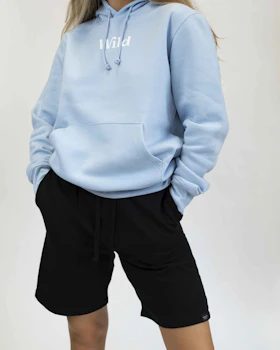 Caption: a woman wearing a light blue hoodie and black shorts