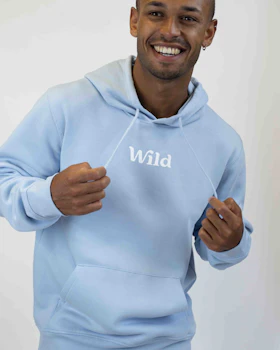 Caption: a man wearing a blue hoodie with the word wild on it