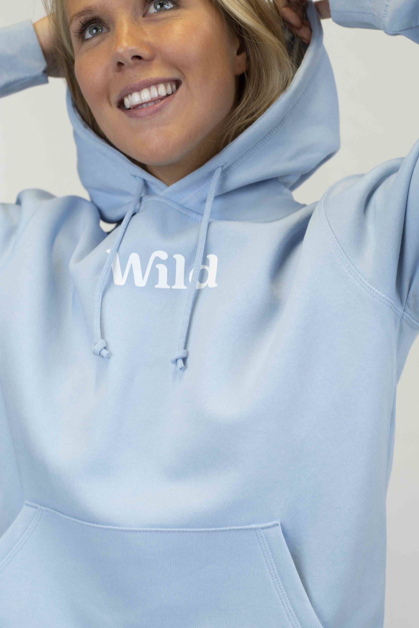 Caption: a woman wearing a blue hoodie with the word wild printed on it
