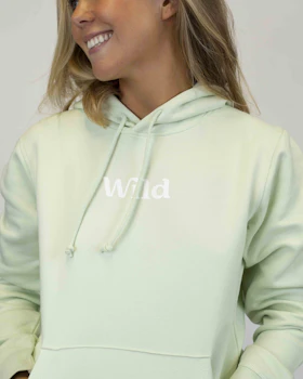 Caption: a woman wearing a light green hoodie with the word wild printed on it