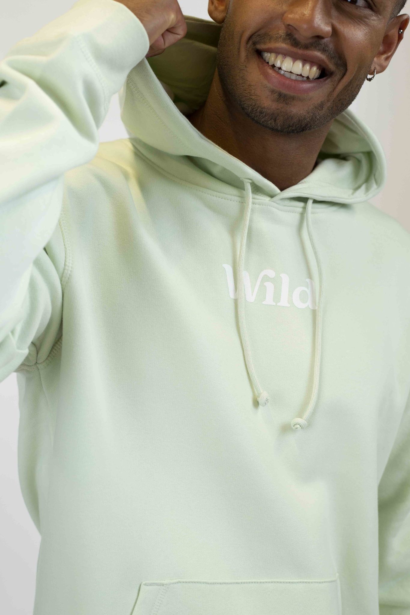 Caption: a man in a light green hoodie smiling