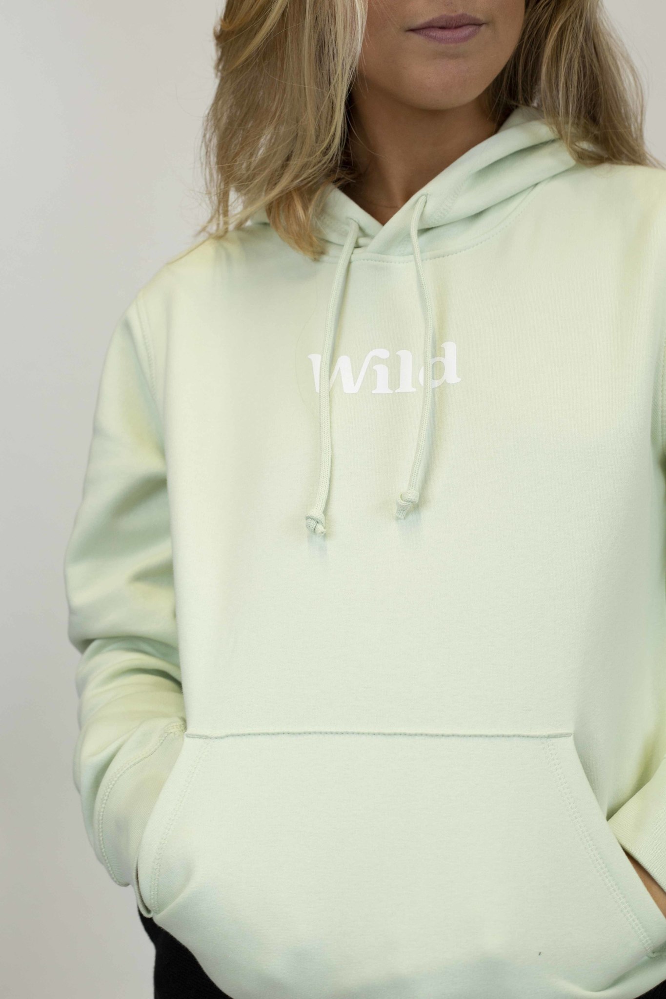Caption: a woman wearing a light green hoodie with the word hawaii printed on it