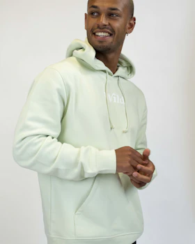Caption: a man in a white hoodie smiles at the camera