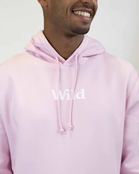 Caption: a man wearing a pink hoodie with the word wild printed on it