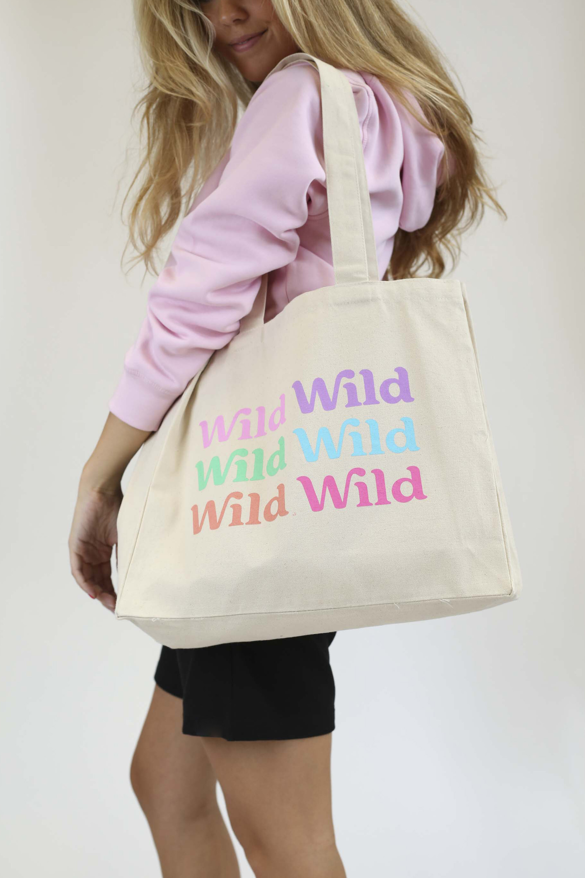 Caption: a woman carrying a tote bag with words on it