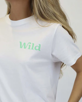 Caption: a woman wearing a white t - shirt with the word wild printed on it