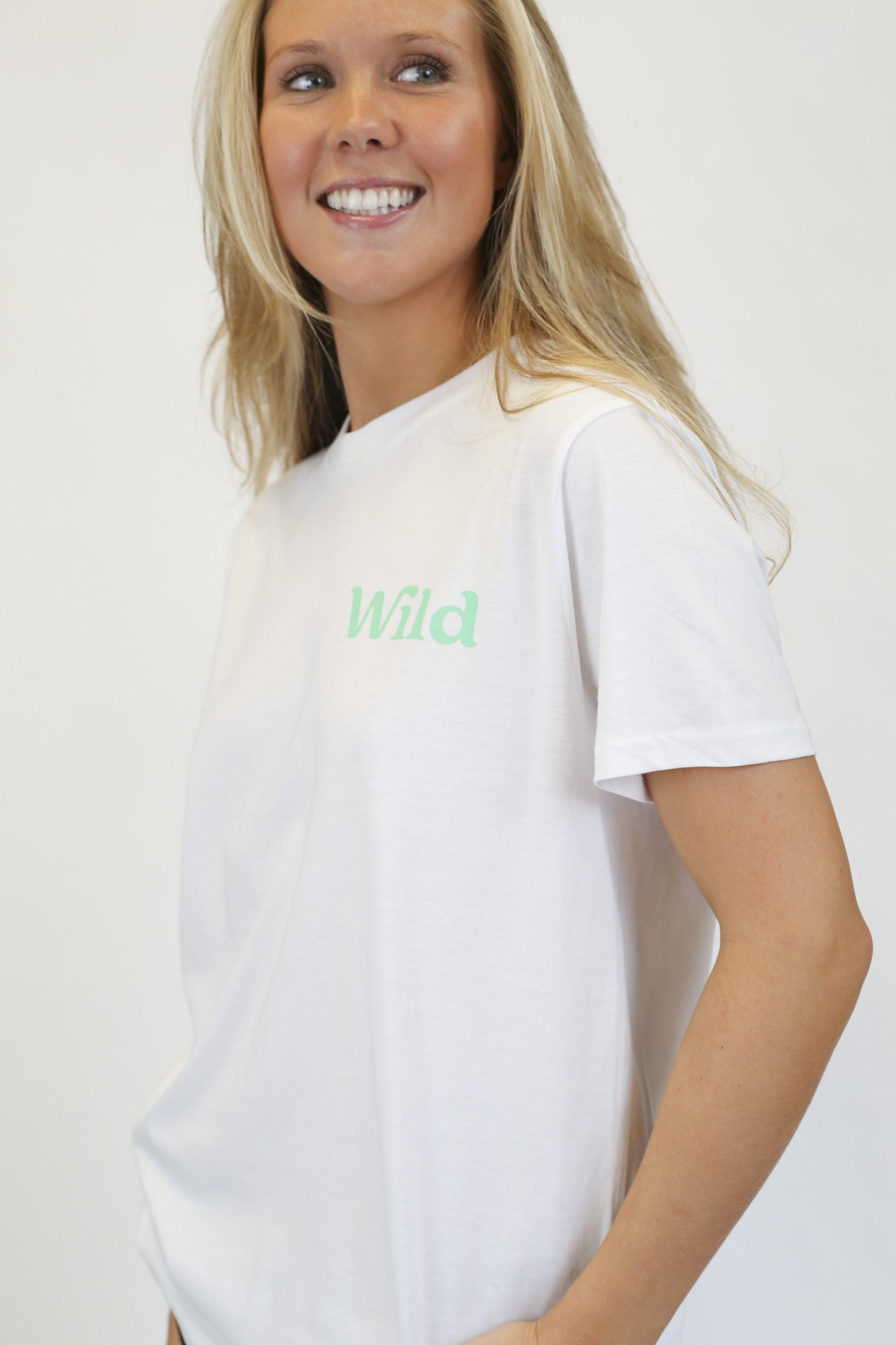 Caption: a woman wearing a white t - shirt with the word wild printed on it