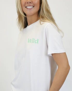 Caption: a woman wearing a white t - shirt with the word wild printed on it