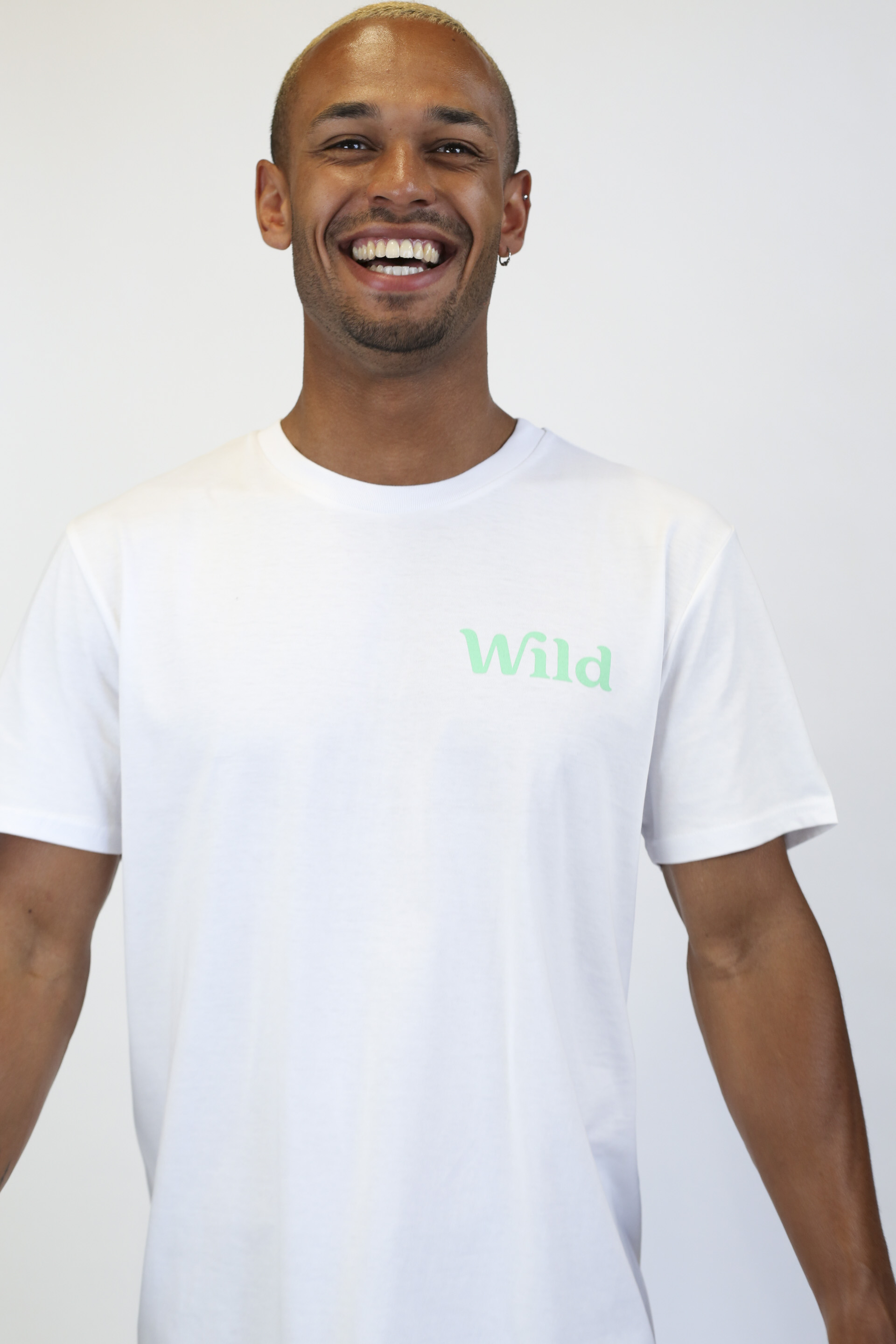 Caption: a smiling man in a white t - shirt with the word wild on it