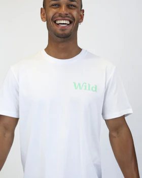 Caption: a smiling man in a white t - shirt with the word wild on it