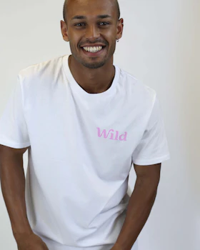 Caption: a man in a white t - shirt with the word wild on it