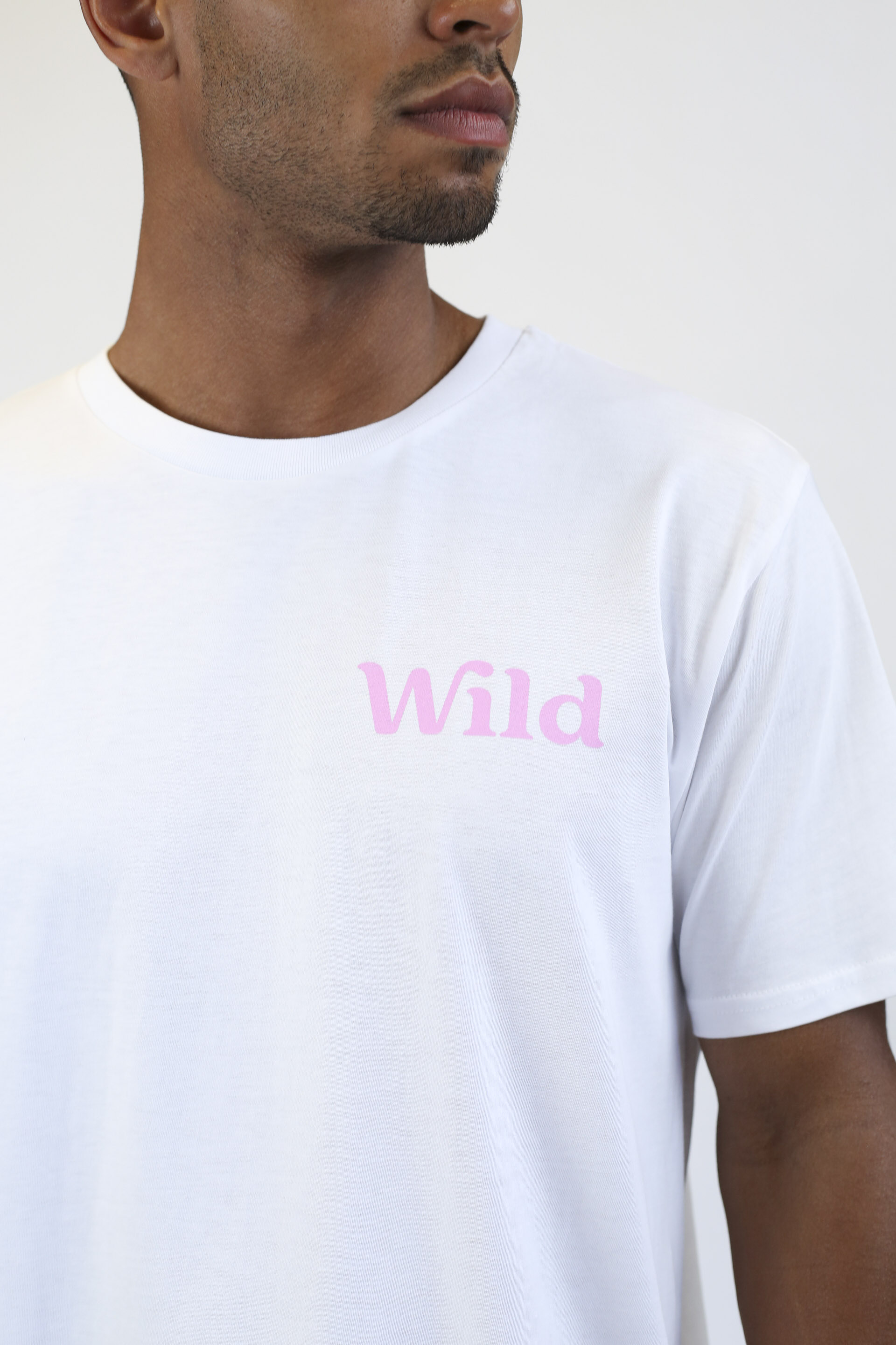 Caption: a man wearing a white t - shirt with the word wild printed on it