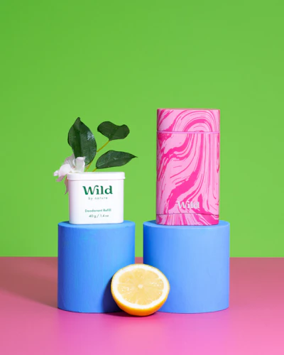 Caption: a pink and blue container next to a lemon and a tube of soap