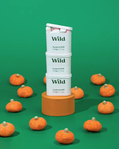 Caption: a stack of oranges sitting on top of a green surface