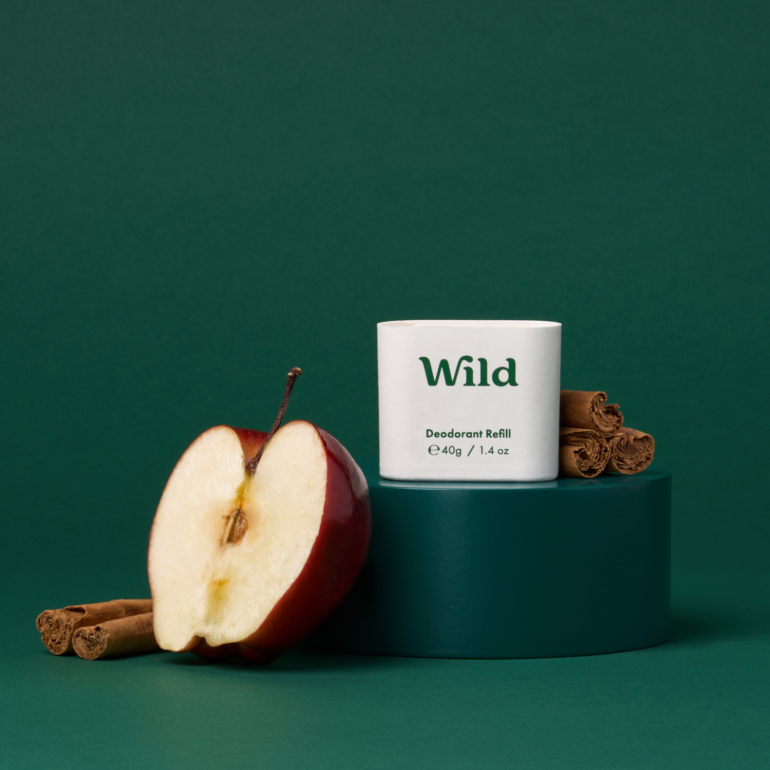 Pie de foto: una manzana y una rama de canela junto a un tubo de salvaje