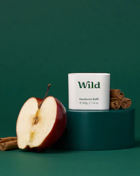 Caption: an apple and cinnamon stick next to a tube of wild