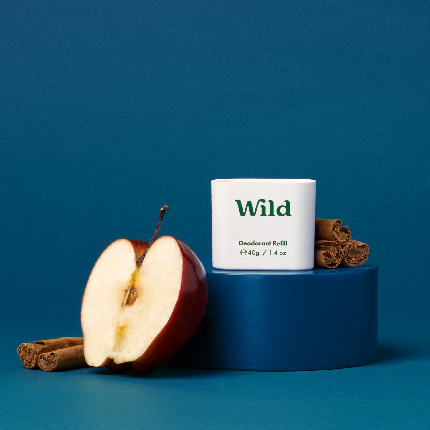 Pie de foto: una manzana y una rama de canela junto a un tubo de salvaje