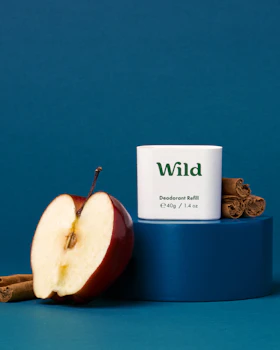 Caption: an apple and cinnamon stick next to a tube of wild