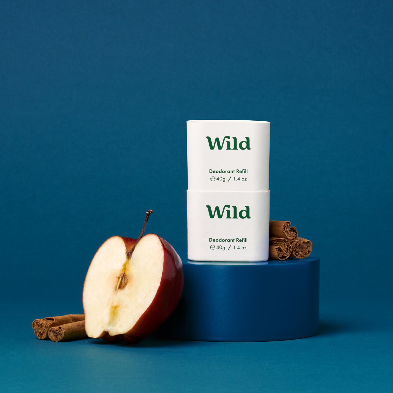 Pie de foto: una manzana y una rama de canela junto a un tubo de salvaje