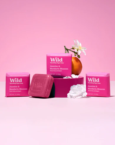 Caption: a pink box with three soaps and a flower in it