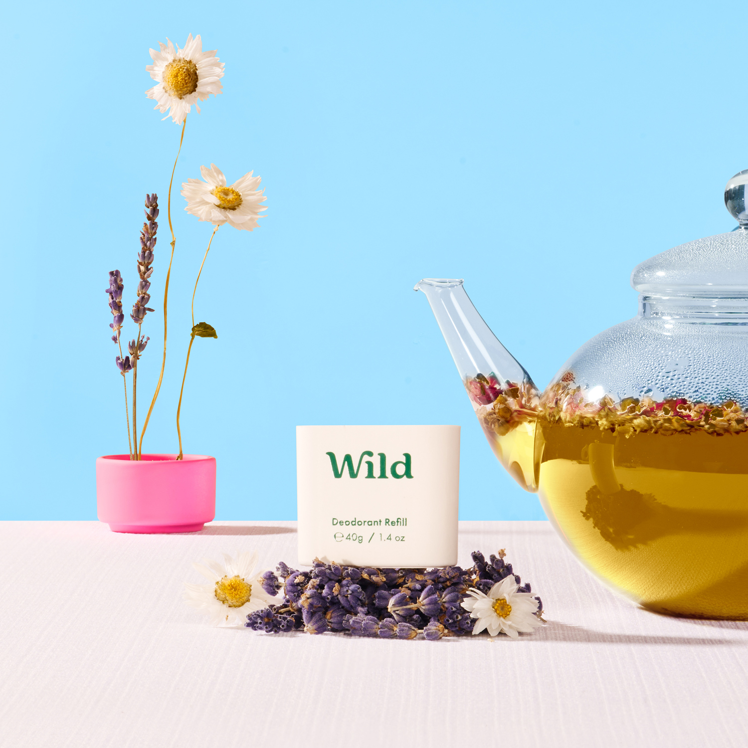 Bildunterschrift: eine mit Wildblumen gefüllte Teekanne neben einer Tasse Tee