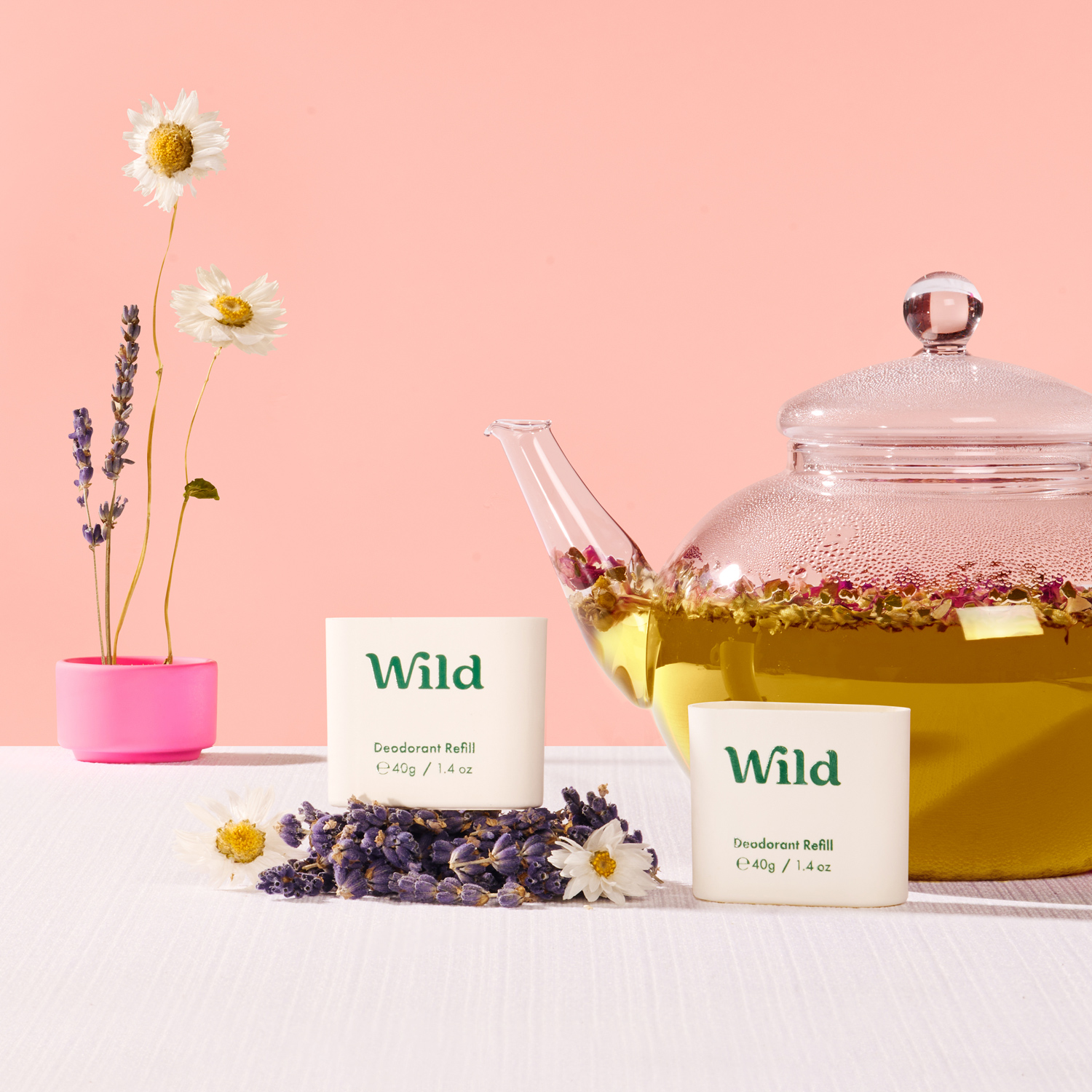 Bildunterschrift: eine Tasse Tee neben einer Teekanne mit wildem Tee