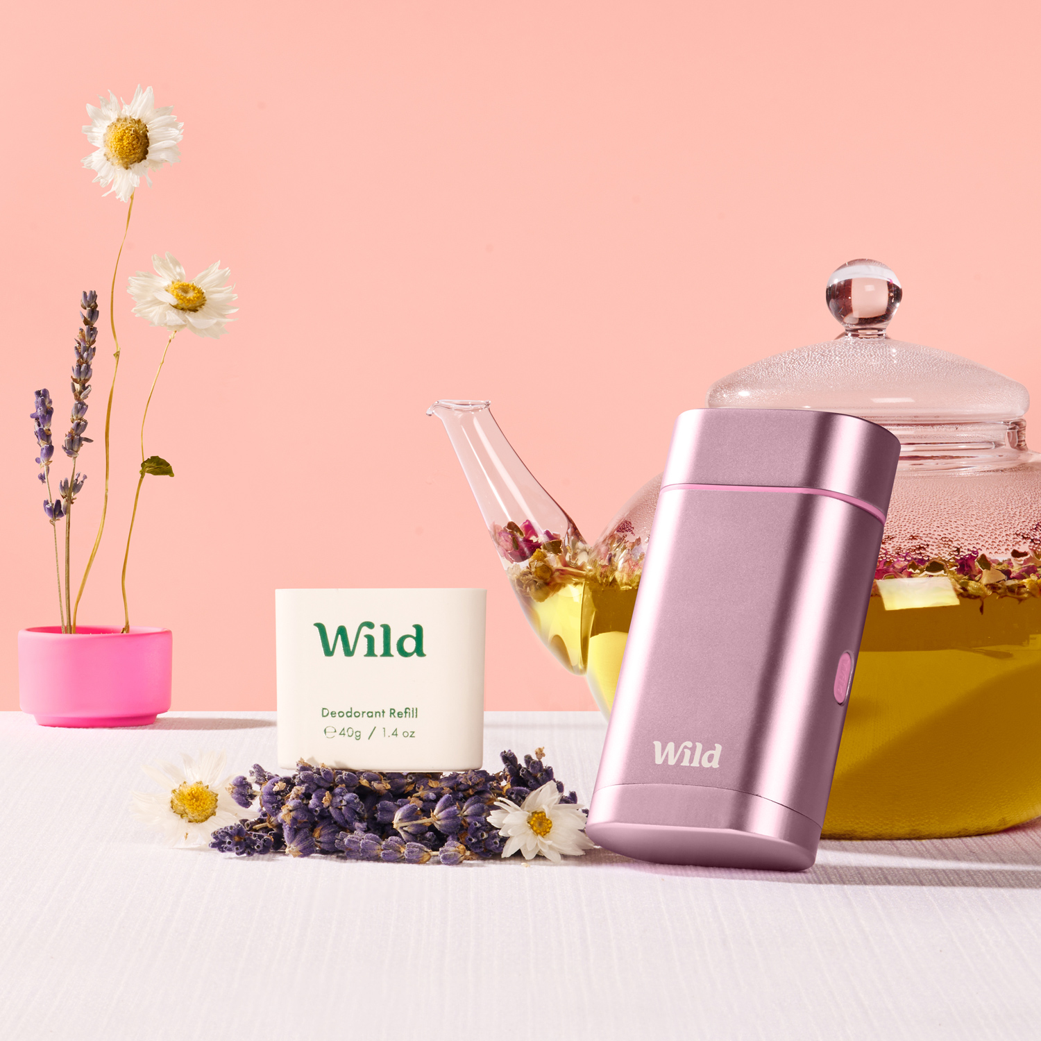 Bildunterschrift: eine rosa Teekanne neben einer Tasse Tee