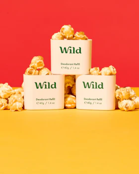 Caption: three white containers filled with popcorn sitting on top of a yellow table