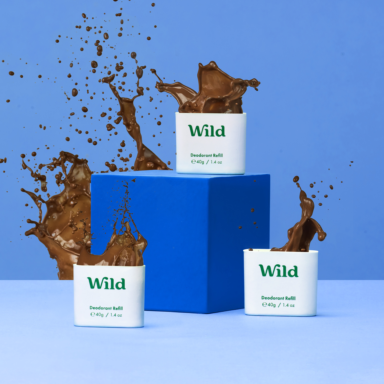 Caption: three cups of chocolate milk splashing out of them