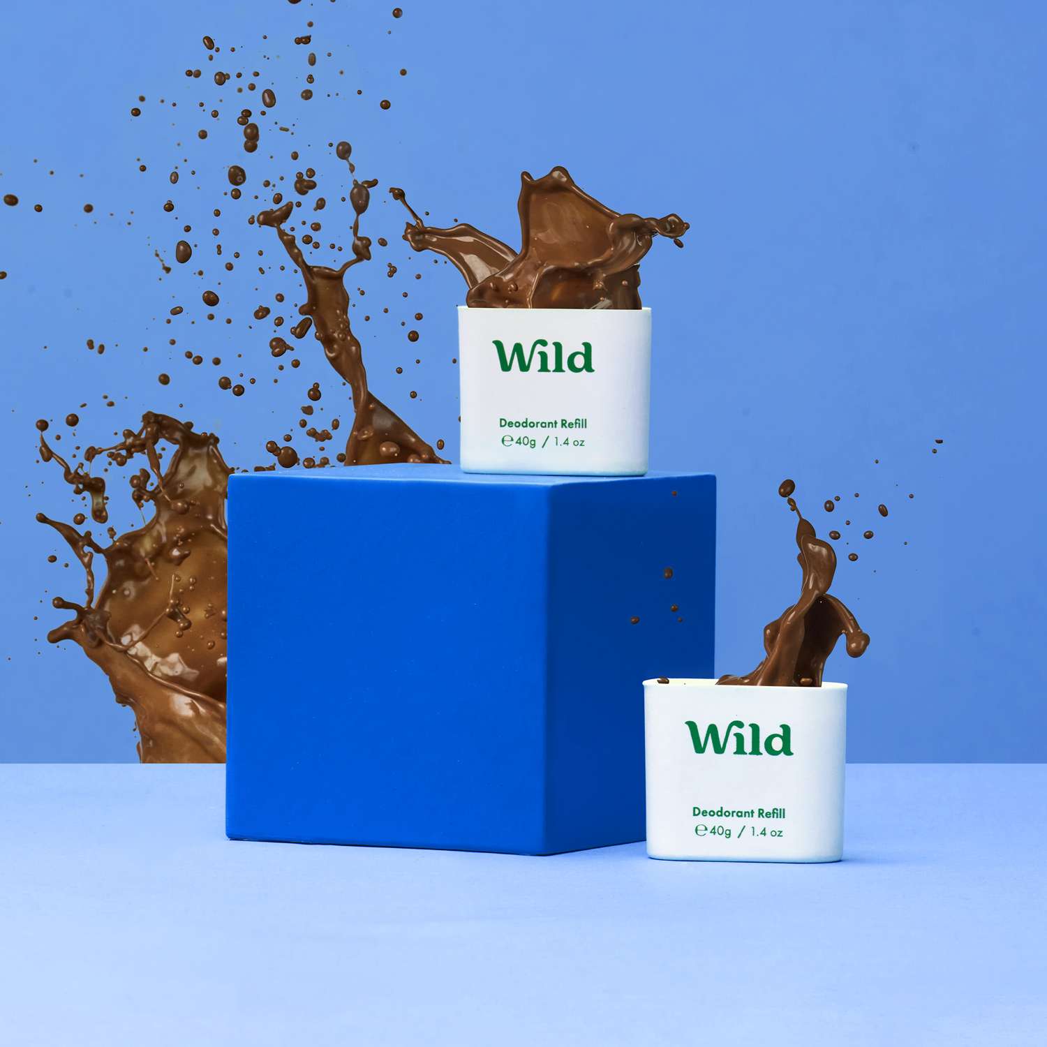 Caption: a couple of cups of chocolate are in front of a blue box