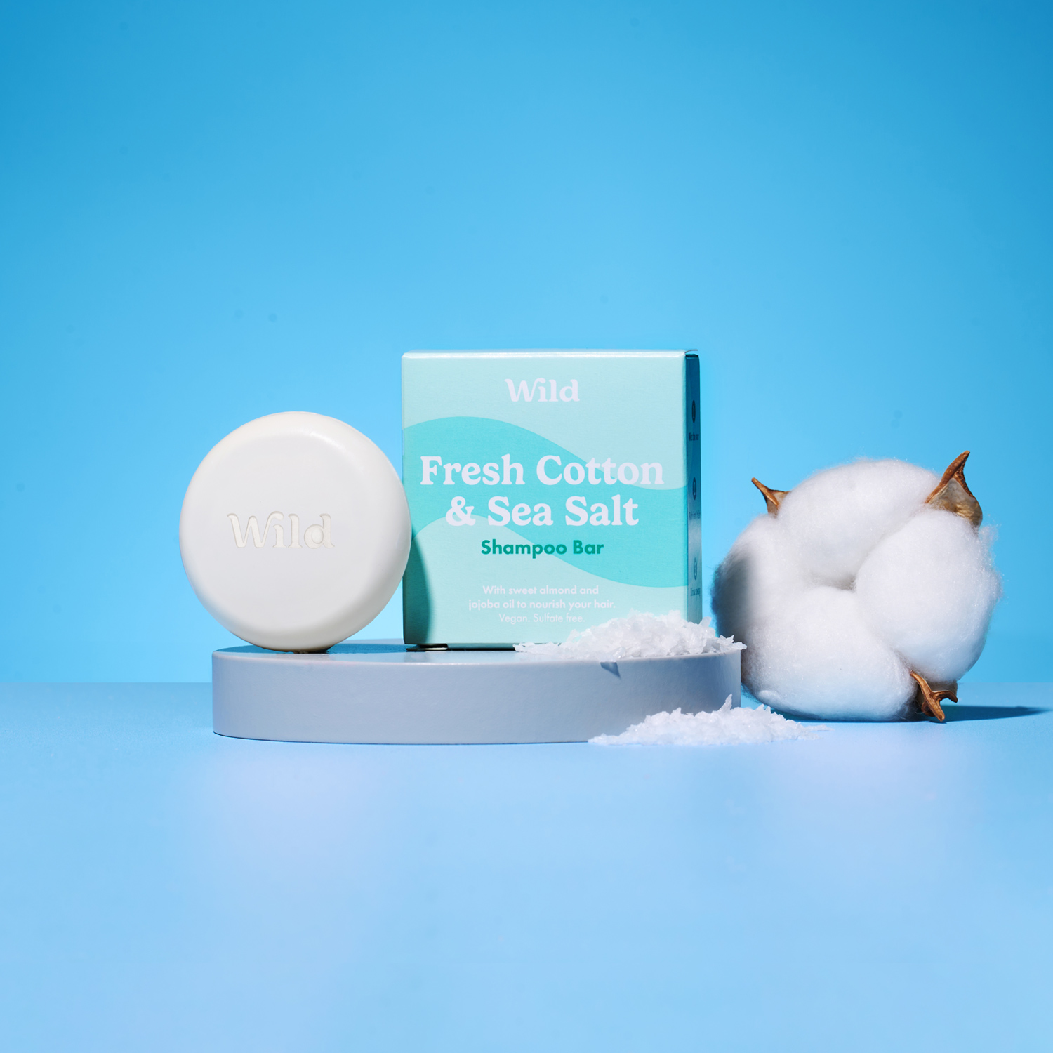 Caption: a soap bar next to cotton on a blue background