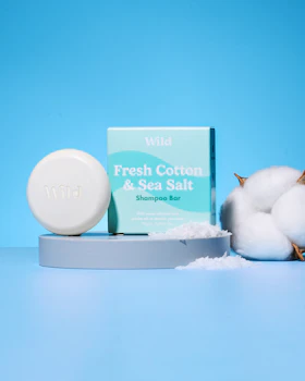 Caption: a soap bar next to cotton on a blue background