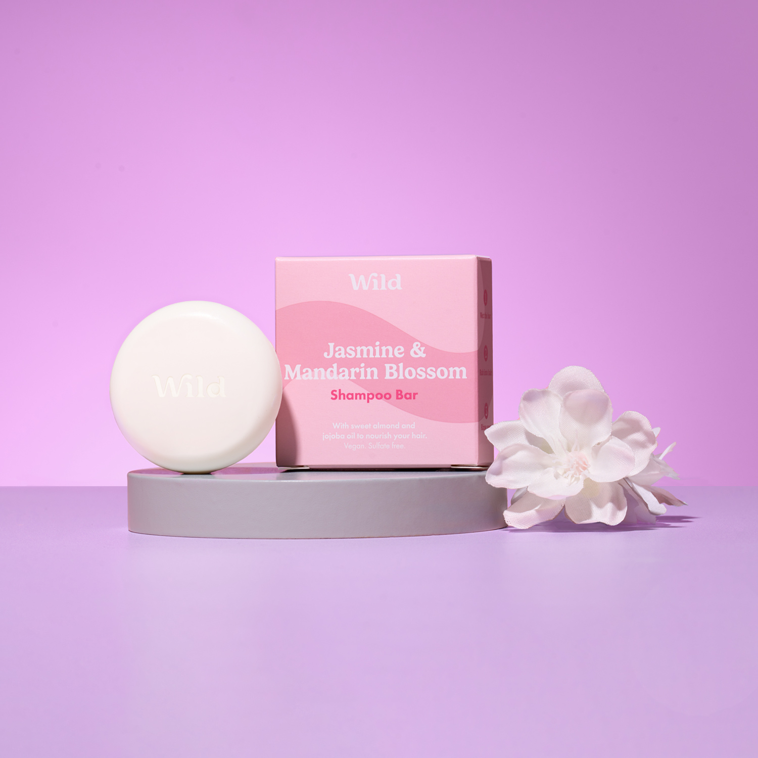 Caption: a soap bar sitting on top of a table next to a white flower